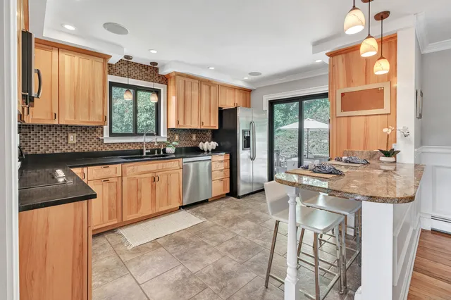 a kitchen with stainless steel appliances granite countertop a stove a sink and a microwave