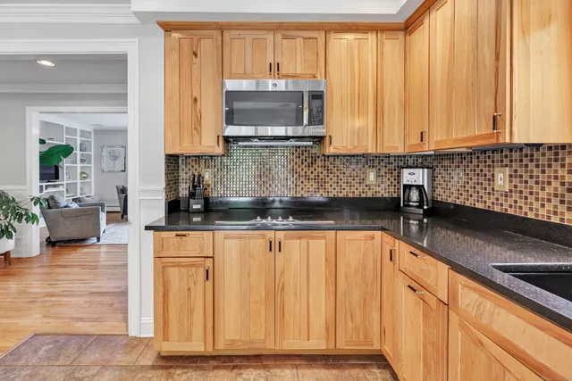 a kitchen with stainless steel appliances granite countertop a sink a stove and a microwave