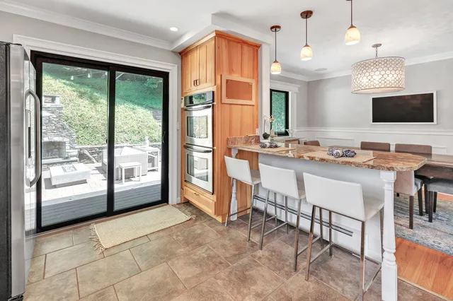 a spacious kitchen with stainless steel appliances granite countertop a stove a sink and a refrigerator
