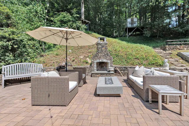 an outdoor sitting area with furniture and umbrella