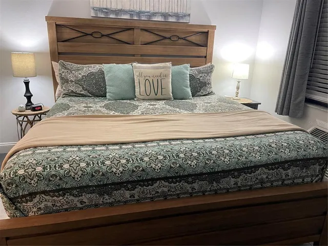 a bed sitting in a bedroom next to a lamp