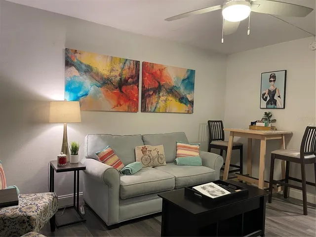 a living room with furniture and a painting on the wall