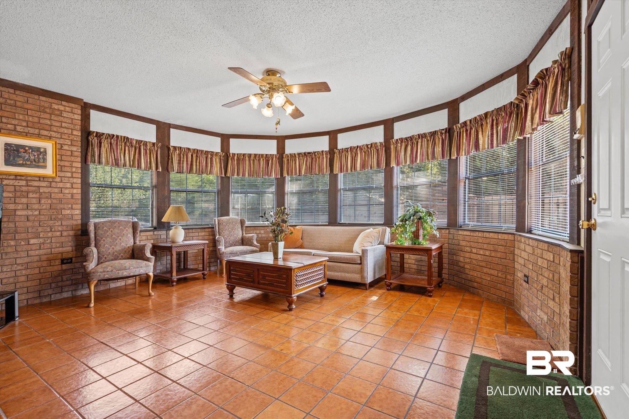 1900 Foxfire Road Mobile, AL 36618 - Photo 9 of 36 Sunroom featuring brick wall, a textured ceiling, and tile patterned flooring