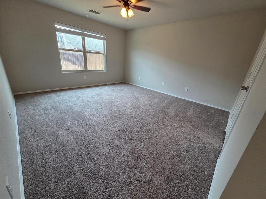 7504 Boat Wind Road Fort Worth, TX 76179 - Photo 15 of 17 an empty room with windows and ceiling fan