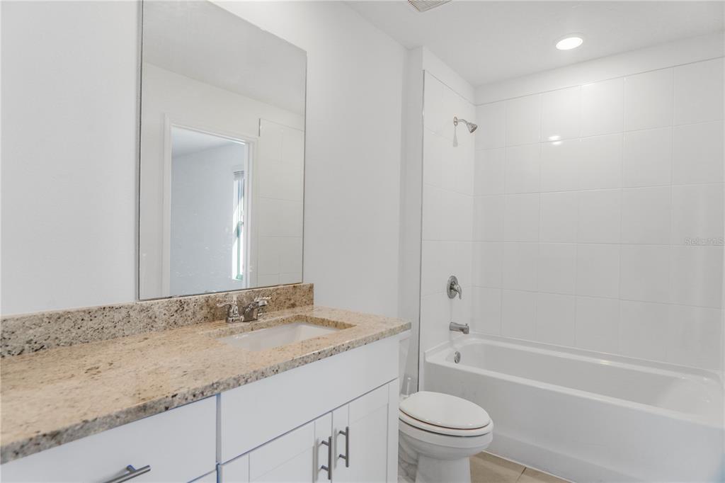 4319 Ranch House Road St. Cloud, FL 34772 - Photo 15 of 47 a bathroom with a granite countertop sink a toilet and a bathtub