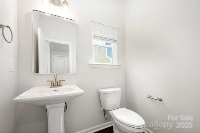 a bathroom with a sink a toilet and mirror