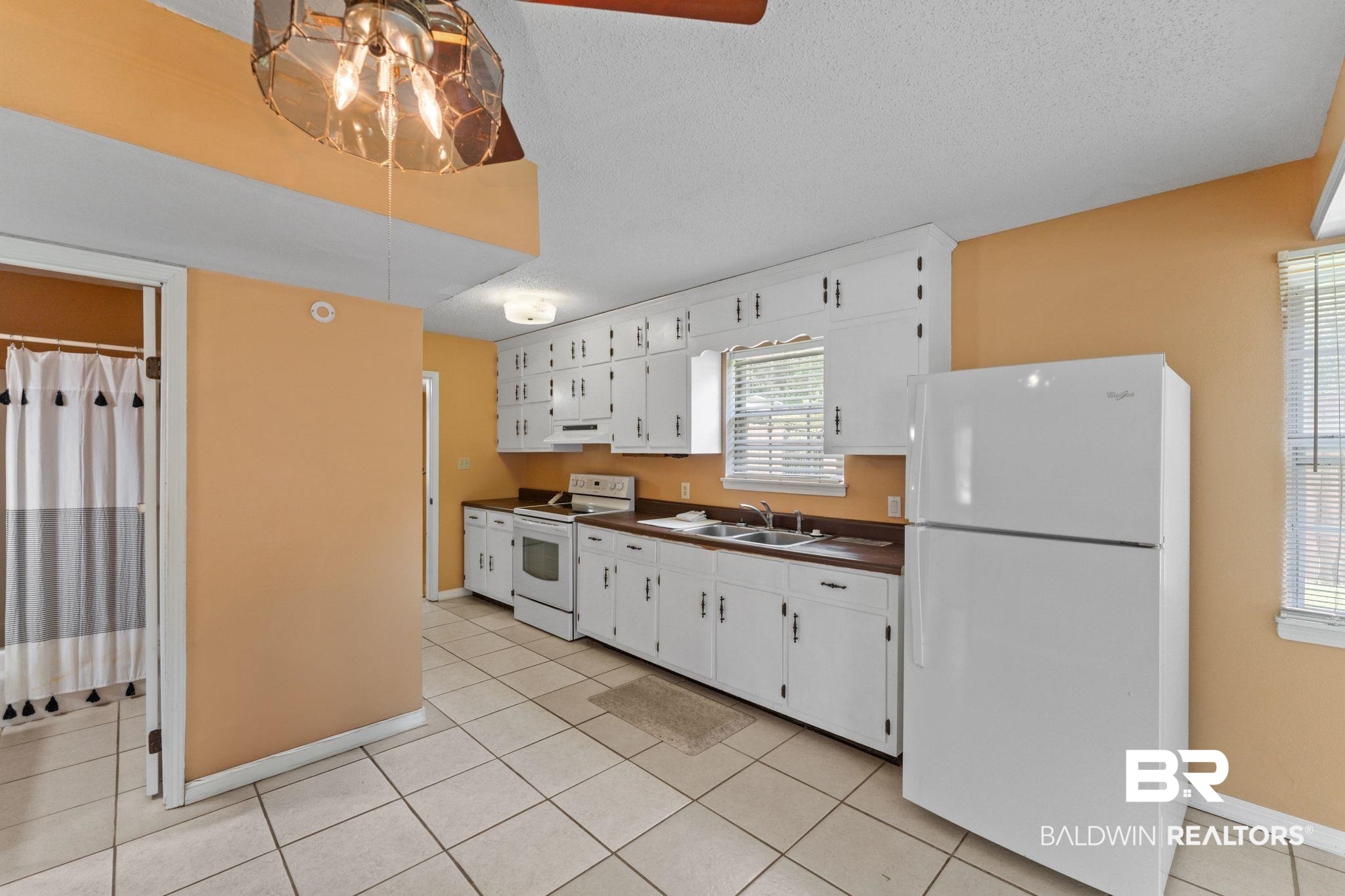 14095 Riverside Drive Foley, AL 36535 - Photo 9 of 30 Kitchen with white appliances, dark countertops, a textured ceiling, white cabinets, and light tile patterned floors