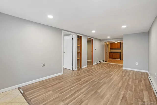 a view of an empty room with wooden floor and closet