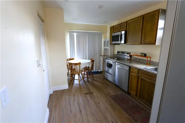 a kitchen with granite countertop wooden floors and wooden cabinets