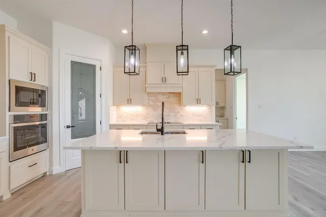a kitchen with kitchen island white cabinets and refrigerator