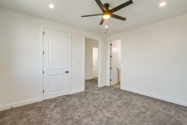 an empty room with closet and a ceiling fan