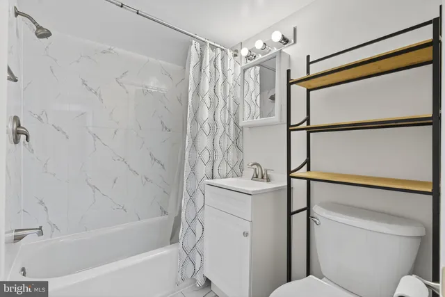 a bathroom with a toilet and a shower curtain