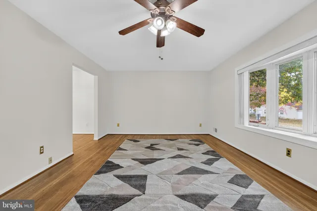 a view of a livingroom with wooden floor and a ceiling fan