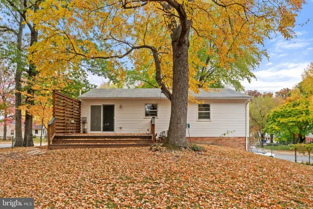 a backyard of a house with white fence and brick wall