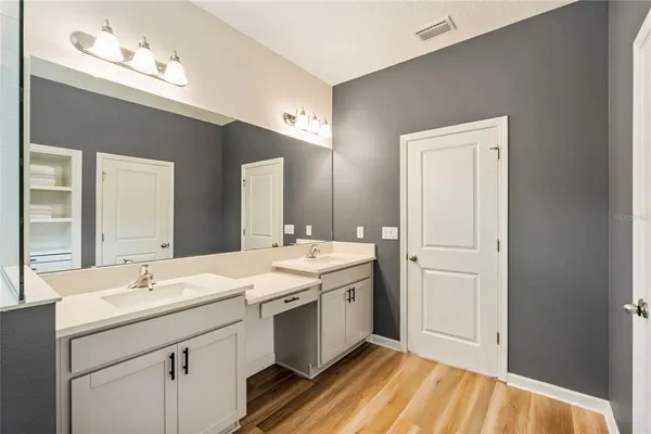 a view of a hallway with wooden floor and a living room