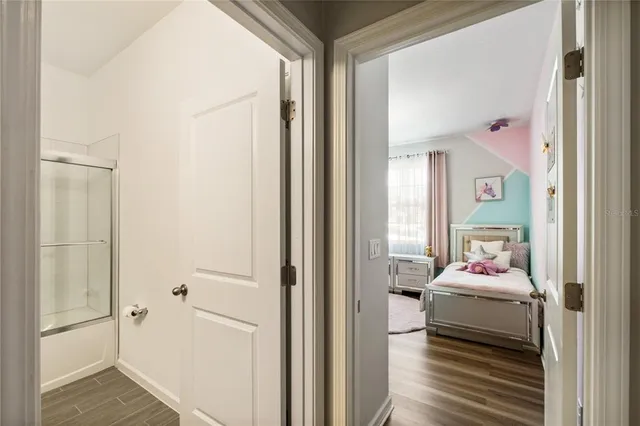 a view of a white house next to a yard with potted plants