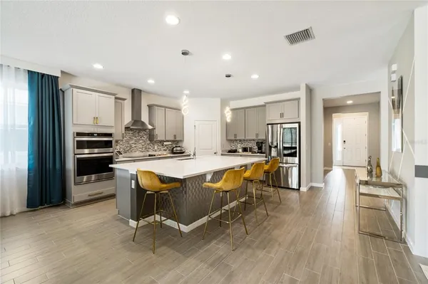 a large kitchen with kitchen island a large counter top space a sink stainless steel appliances and cabinets