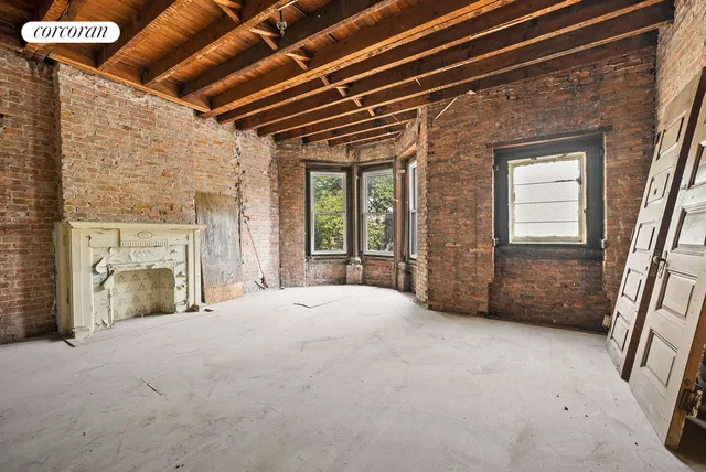 a view of a livingroom with a fireplace and windows