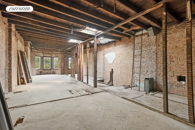 a view of an empty room with a fireplace and windows