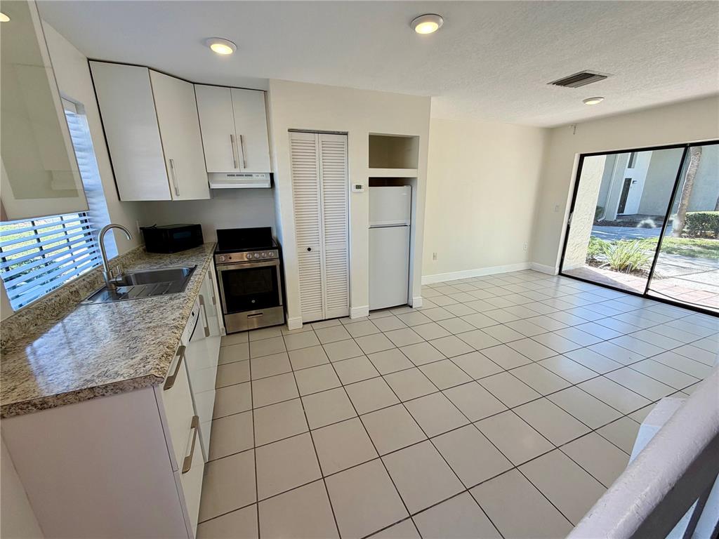 10260 Turkey Lake Road, Unit 149 Orlando, FL 32819 - Photo 6 of 18 a kitchen with stainless steel appliances granite countertop a refrigerator and a stove