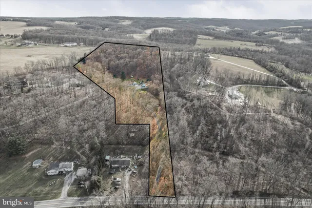 a view of a dry yard with wooden fence