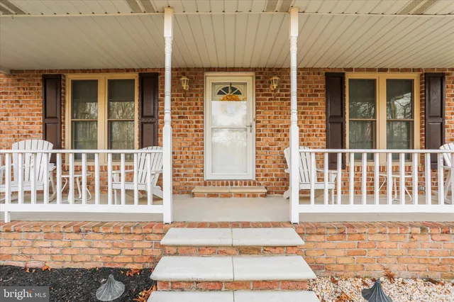 a front view of a house with a garden and trees