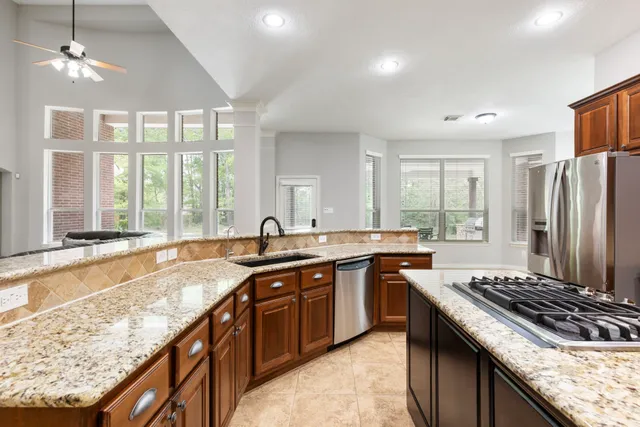 a kitchen with stainless steel appliances granite countertop a sink stove and refrigerator