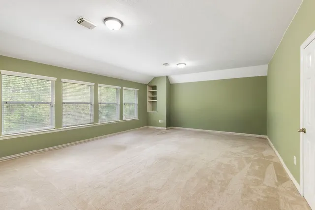 wooden floor in an empty room with a chandelier fan