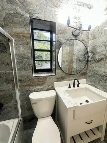 a bathroom with a toilet sink and mirror