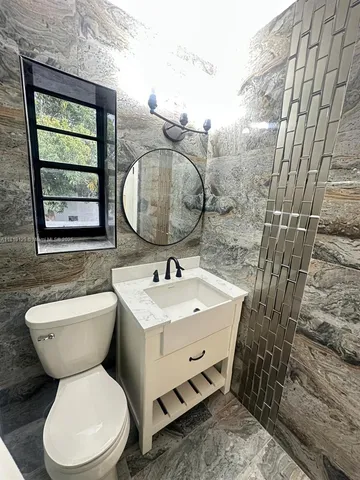 a bathroom with a toilet sink and mirror