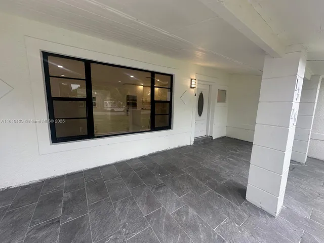 a view of a hallway with wooden floor and entryway