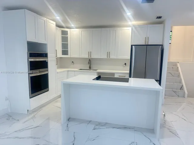a kitchen with cabinets and stainless steel appliances