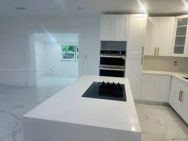 a kitchen with a sink a stove and cabinets