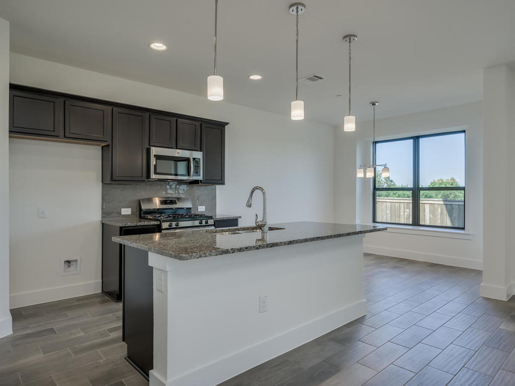 12327 Maypole Bend Austin, TX 78717 - Photo 9 of 30 a kitchen with stainless steel appliances granite countertop a sink a stove a refrigerator a window and cabinets