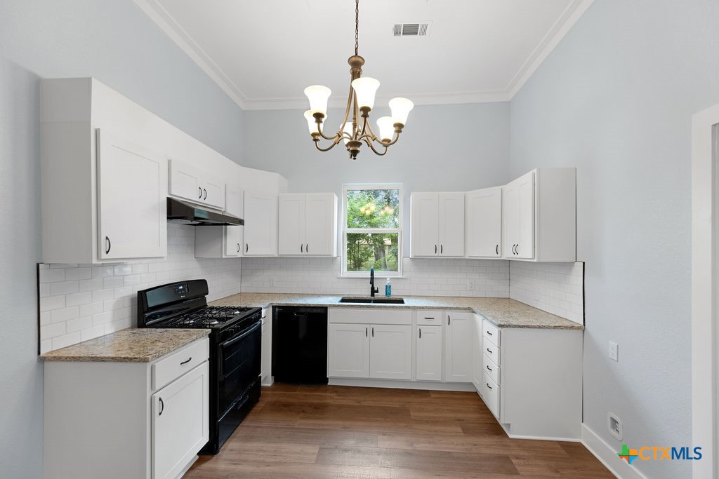 607 West 3rd Street Eddy, TX 76524 - Photo 9 of 29 a kitchen with cabinets a window and stainless steel appliances