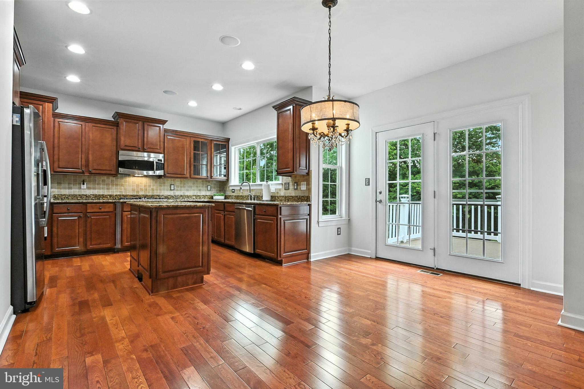 1901 Eamons Way Annapolis, MD 21401 - Photo 30 of 64 a kitchen with stainless steel appliances granite countertop wooden floors and white cabinets