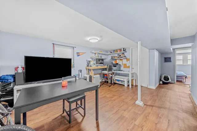 a view of a livingroom with workspace and a flat screen tv