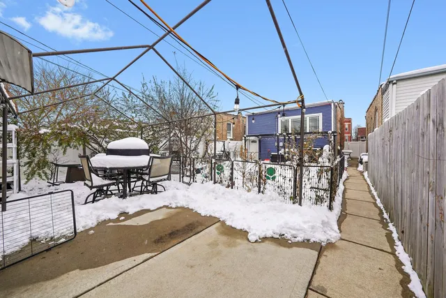 a view of a backyard with table and chairs under an umbrella