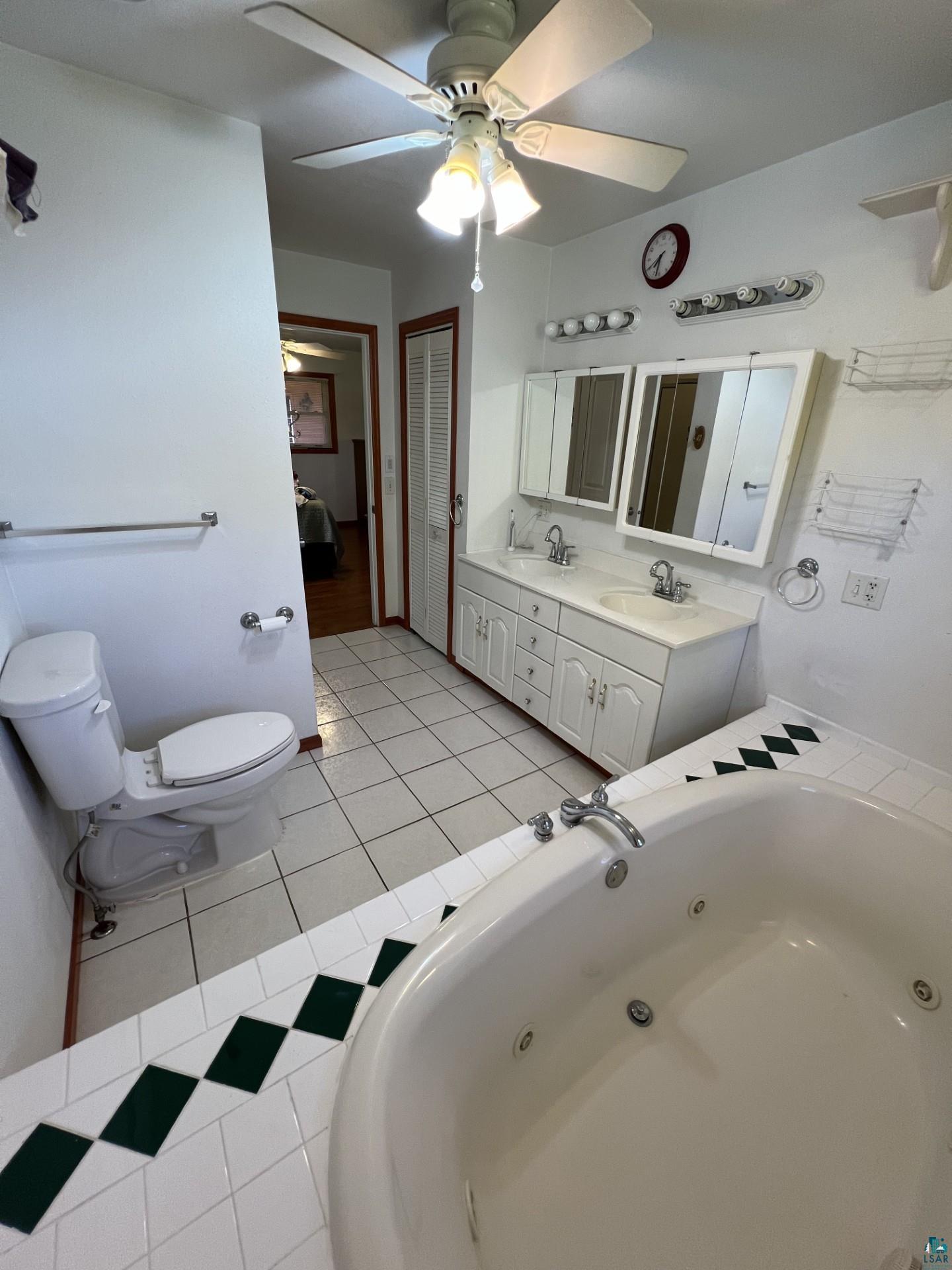 5144 Eagle Lake Road Duluth, MN 55803 - Photo 25 of 47 Bathroom featuring dual sinks, ceiling fan, toilet, and large vanity