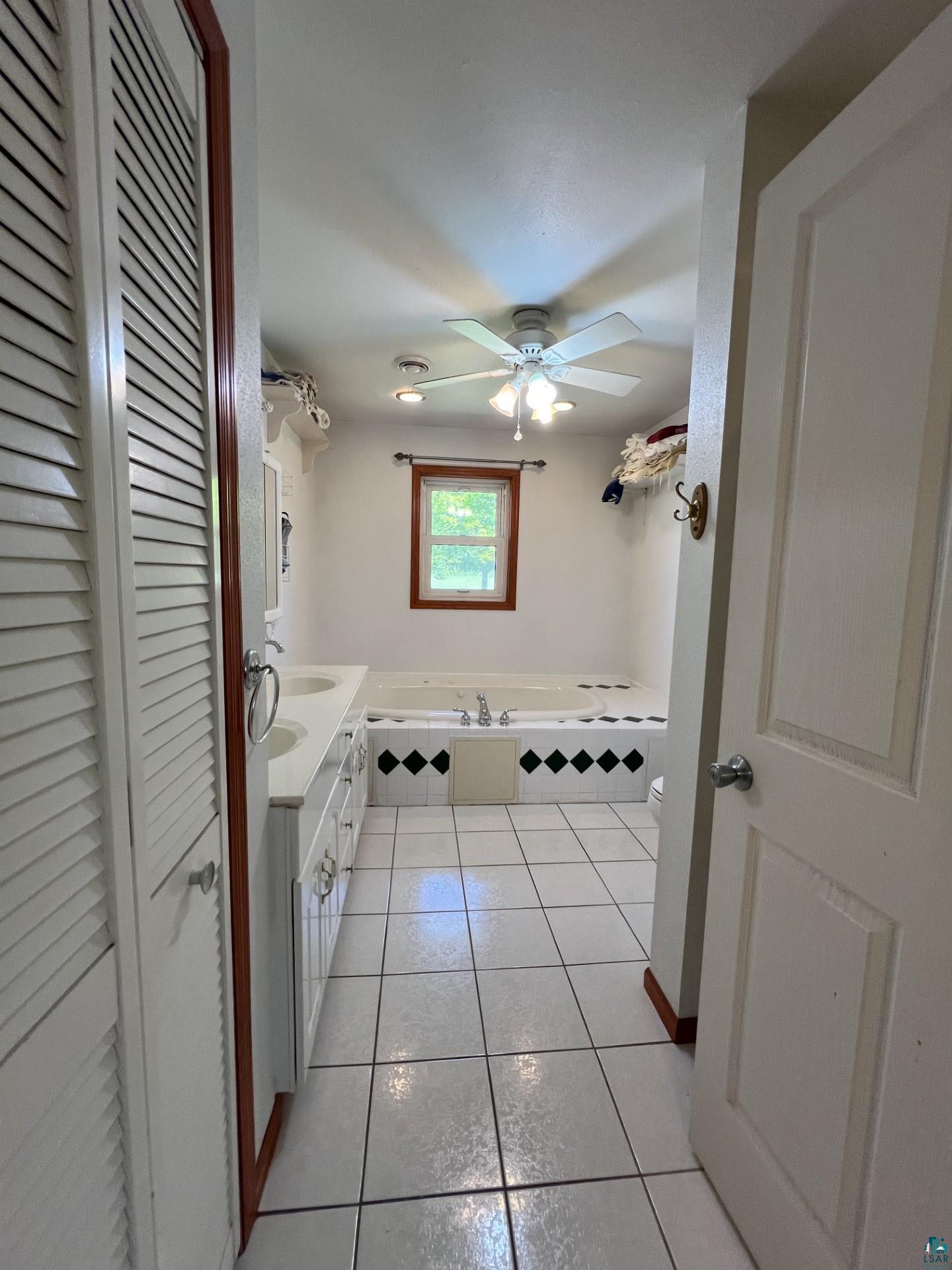 5144 Eagle Lake Road Duluth, MN 55803 - Photo 26 of 47 Bathroom with tiled bath, tile flooring, vanity, and ceiling fan