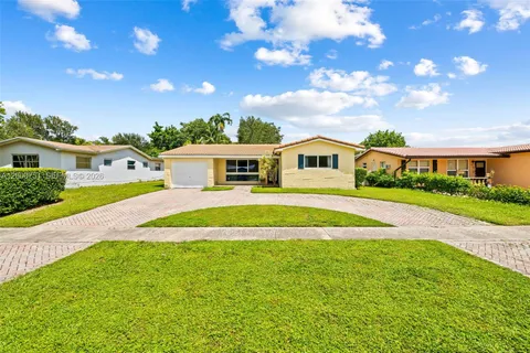 a view of house with swimming pool and yard