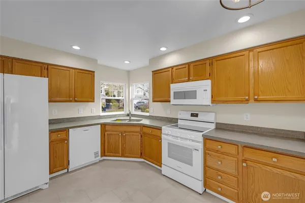 a kitchen with white cabinets and white appliances