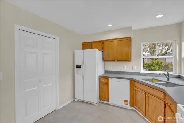 a kitchen with stainless steel appliances granite countertop a sink and a refrigerator