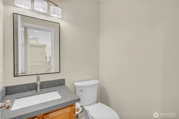 a bathroom with a toilet a sink and mirror