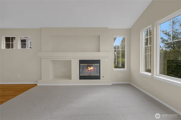 a view of an empty room with a window and fireplace