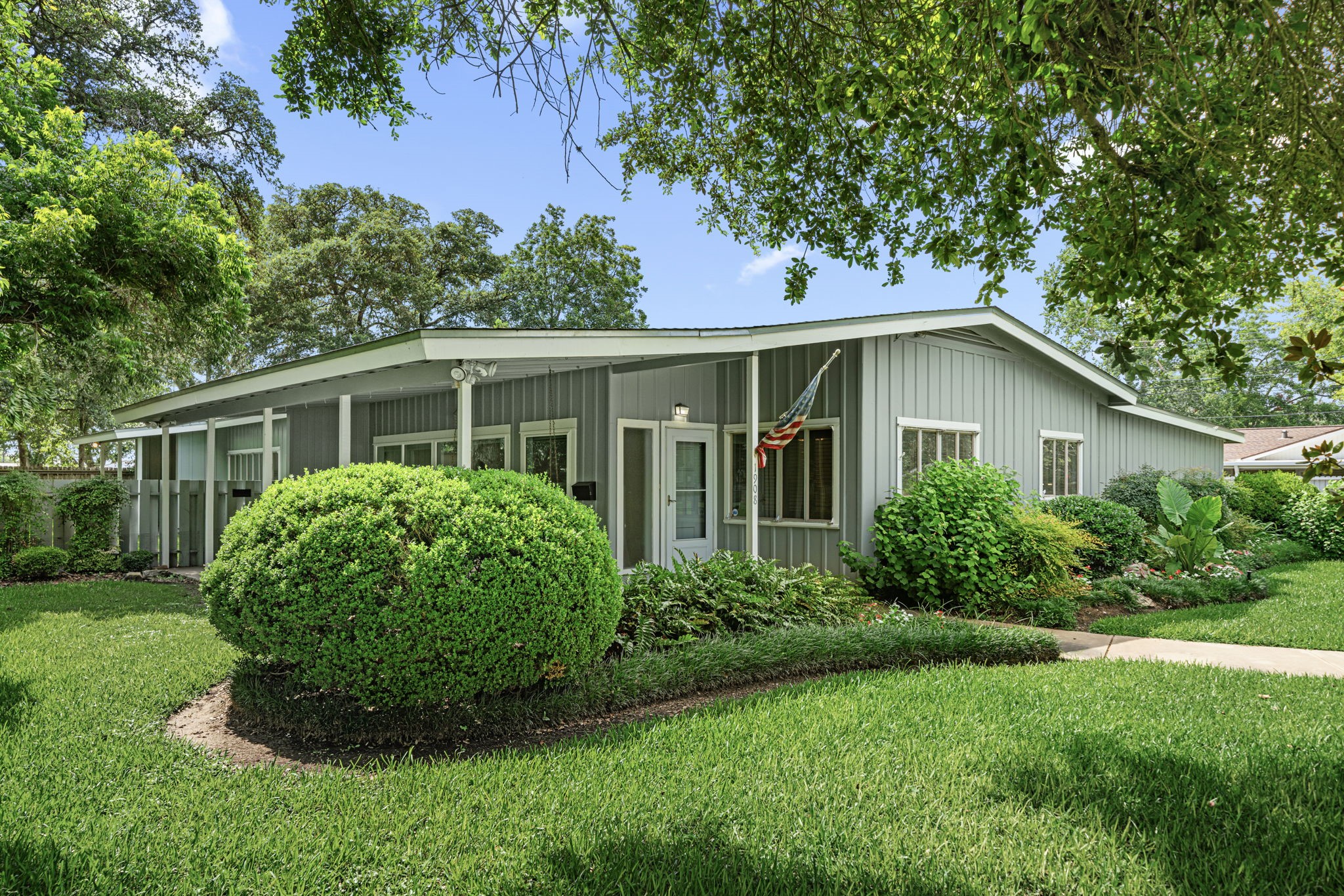 a view of a house with a yard and potted plants