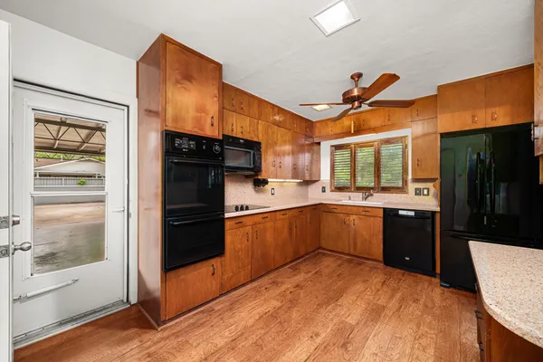 a kitchen with stainless steel appliances a sink cabinets and wooden floor