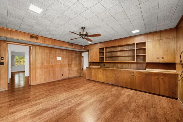 a view of empty room with wooden floor and fan