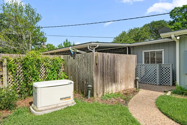 a white house with a small yard and wooden fence