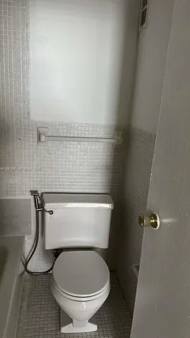 a bath tub sitting next to a white toilet and a shower